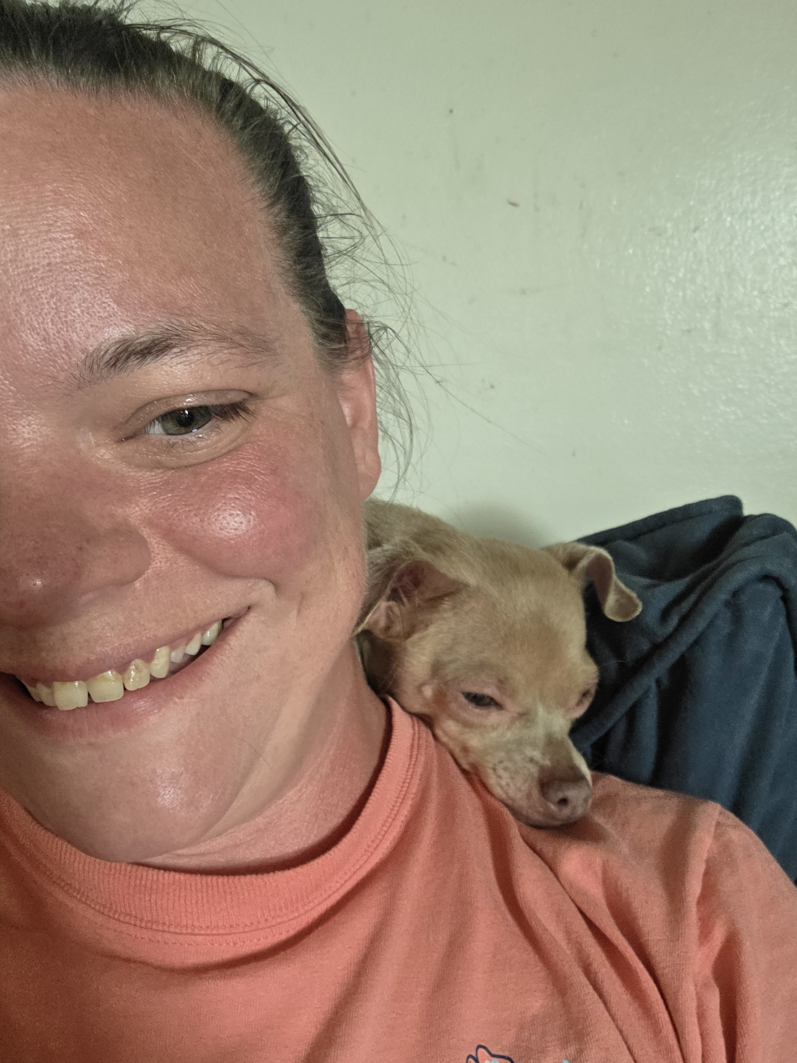 Christine with a dog resting its head on her shoulder